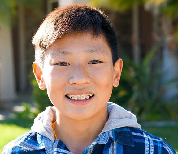 Young boy smiling with traditional metal braces in Lake Zurich, IL