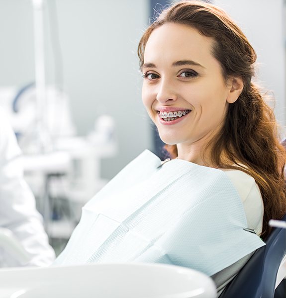 Woman with braces smiling in dental treatment room