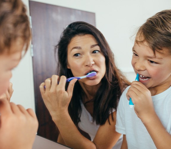 Mother and child brushing teeth to prevent dental emergencies