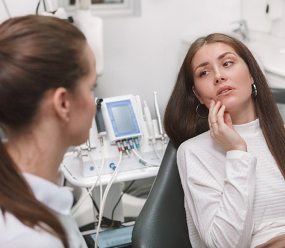 A woman with a toothache visiting her dentist