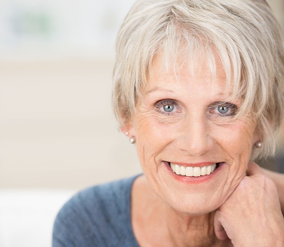 Woman sharing beautiful smile after dental implant tooth replacement