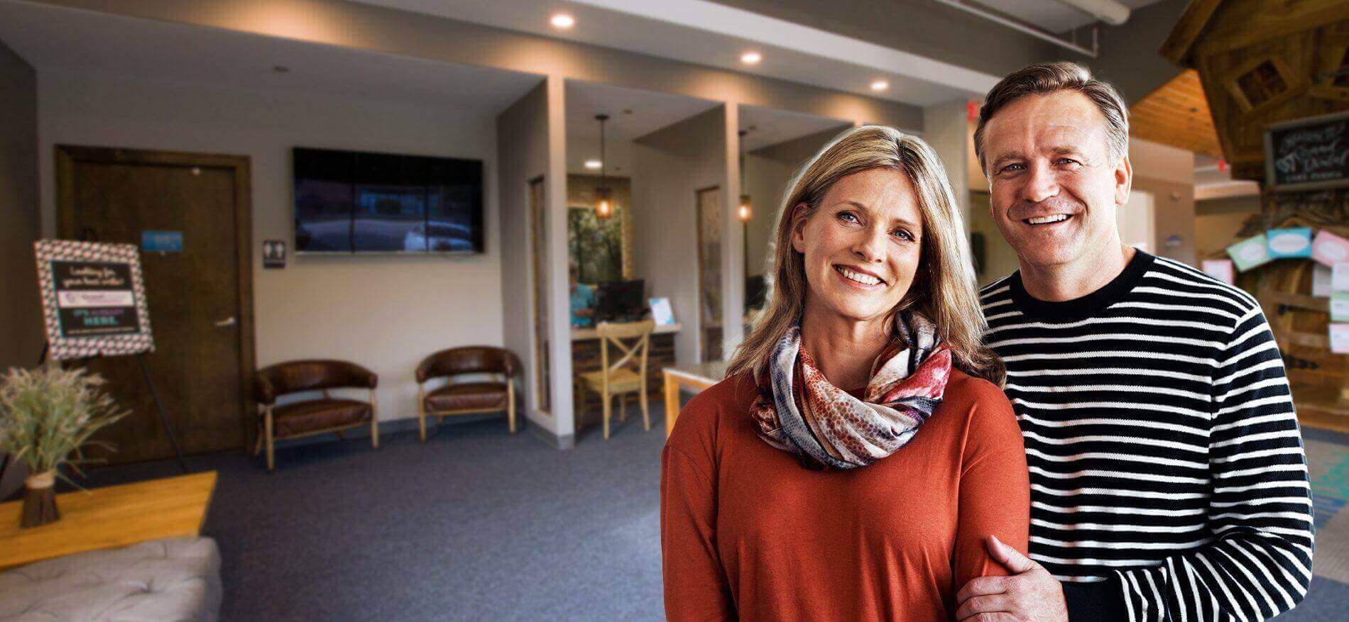 Older man and woman smiling in their dental office