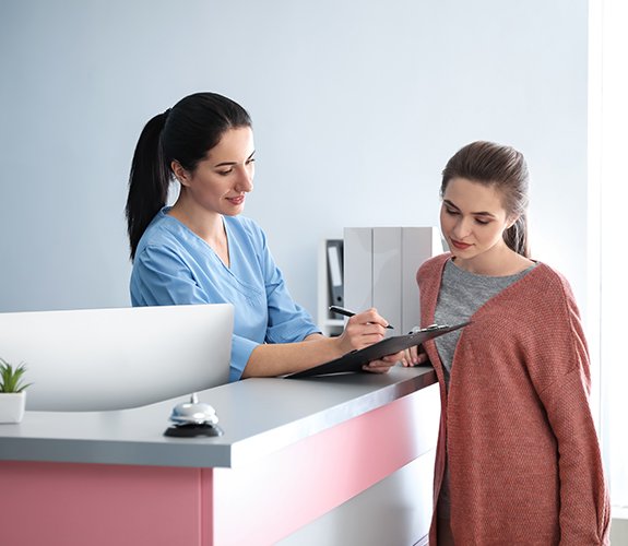 Dental patient and team member reviewing dental insurance forms