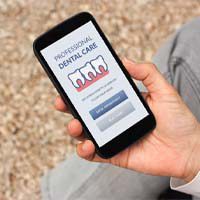 Person holding a phone with dental insurance information
