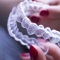 Up-close view of a hand holding clear aligners