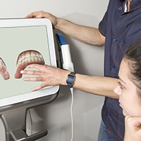 Girl listening as dentist explains dental impressions on a screen