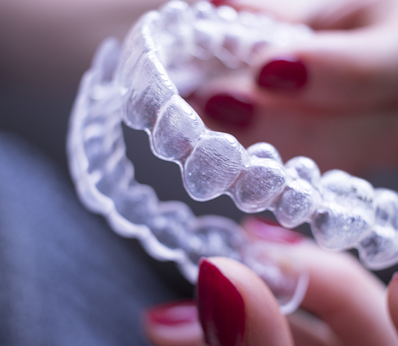 Person holding up an Clear Aligners aligner tray