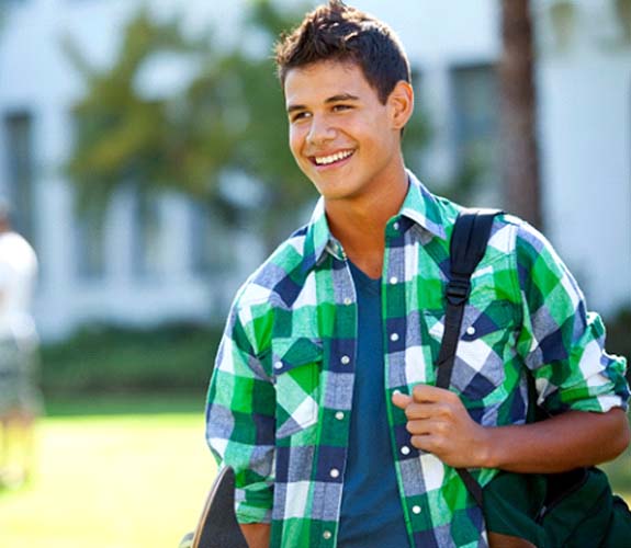 Teen boy smiling and walking outside after wearing Invisalign Teen in Lake Zurich, IL