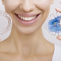 Closeup of patient holding retainers used after orthodontics in Lake Zurich, IL