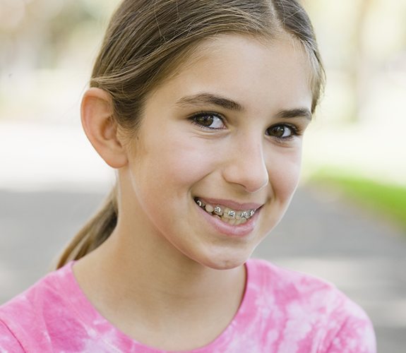 Preteen girl with metal braces smiling