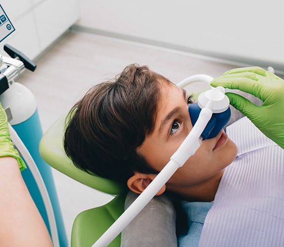 Relaxed child with nitrous oxide sedation dentistry mask in place