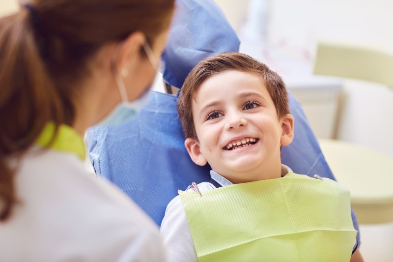 Little boy showing baby teeth to dentist