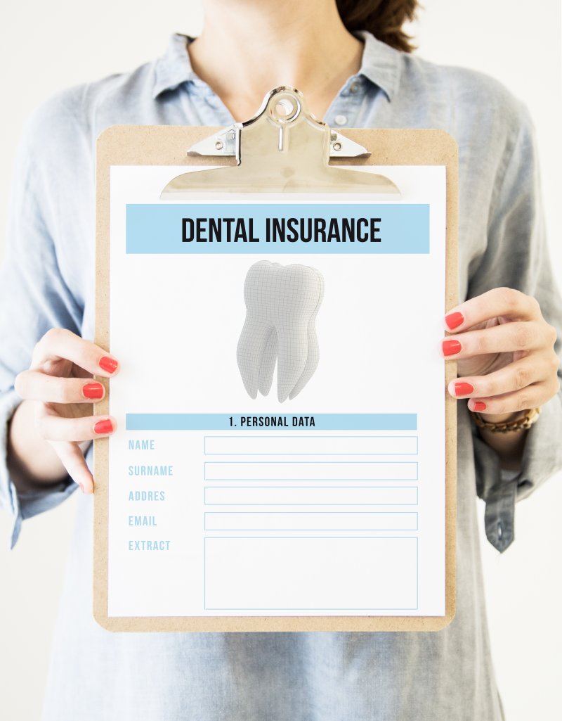 Woman holding up clipboard with dental insurance form