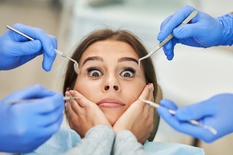 woman fearful of dentist and surrounded by dental instruments