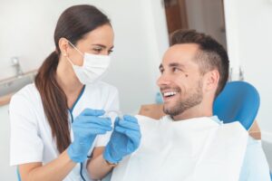 man smiling while his dentist talks about clear aligners